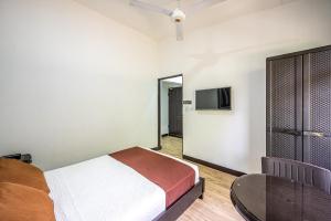 um quarto com uma cama e uma televisão de ecrã plano em Jaco Lodge Quiet Place em Jacó
