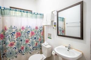 a bathroom with a sink and a toilet and a shower curtain at Jaco Lodge Quiet Place in Jacó