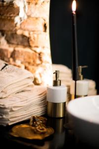 een badkamer met een wastafel, een kaars en handdoeken bij World Studio Sibiu in Sibiu