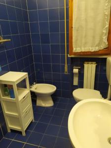 Baño de azulejos azules con aseo y lavamanos en Il mio piccolo angolo di mare en Viareggio