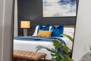 1 dormitorio con 1 cama con almohadas azules y amarillas en Cozy Chic Countryside Haven, Sleeps 4, Firepit, en Sturbridge