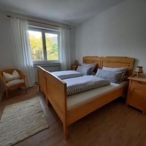 a bedroom with a large bed and a window at Ferienhaus-Ferienwohnung Weitblick mit Garten und malerischem Bergpanorama in Oberammergau
