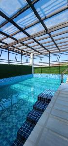 a swimming pool with blue tiles and a roof at Rock Lake Villa in Vagamon
