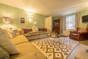 uma sala de estar com um sofá e uma mesa em Owl Cottage Woodside em Burnham Market