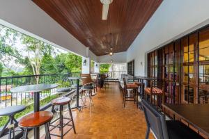 a restaurant with tables and chairs and a balcony at Bangsar Villa for groups, event space and family fun in Kuala Lumpur