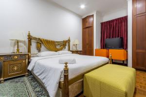 a hotel room with a bed and a tv at Bangsar Villa for groups, event space and family fun in Kuala Lumpur