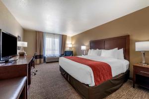 a hotel room with a bed and a flat screen tv at Comfort Inn & Suites in Goodland