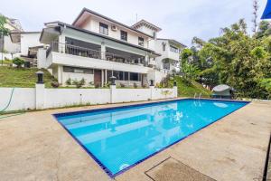 a large swimming pool in front of a house at Bangsar Villa for groups, event space and family fun in Kuala Lumpur