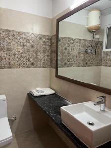 a bathroom with a sink and a mirror at Risals Home Stays in Greater Noida