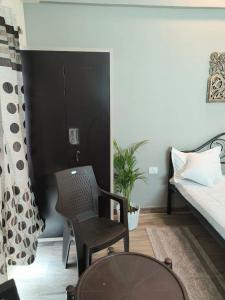 a living room with a chair and a bed at Risals Home Stays in Greater Noida
