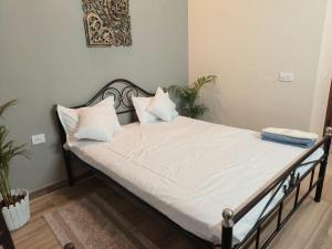 グレーター・ノイダにあるMurti Home Staysの部屋にある白いシーツと枕が置かれたベッド