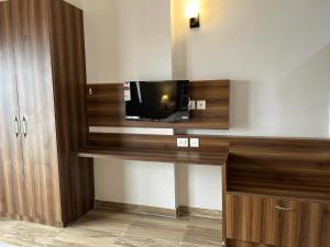 a room with a flat screen tv on a wall at Risals Home Stays in Greater Noida