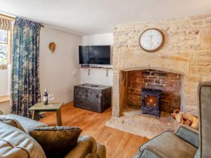 ein Wohnzimmer mit einem Steinkamin und einer Uhr in der Unterkunft 1 Bed in Montacute 93149 in Montacute