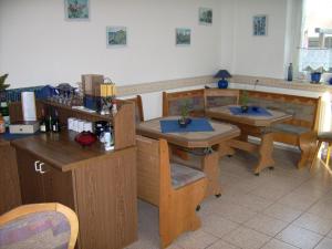 a restaurant with wooden tables and chairs and a counter at Pension Regenbogen in Stralsund