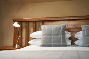 a bedroom with a bed with pillows and a lamp at Ulbster Arms Hotel near Thurso in Halkirk