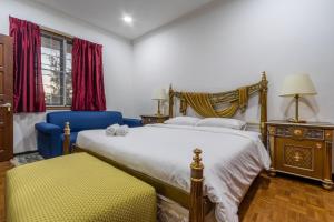 a bedroom with two beds and a blue chair at Bangsar Villa for groups, event space and family fun in Kuala Lumpur +53 photos