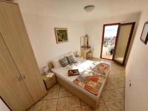 a small bedroom with a bed and a window at Apartmani Dalex in Budva