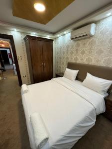 a bedroom with a large white bed and a heater at al-burj apart 7th circle in Amman
