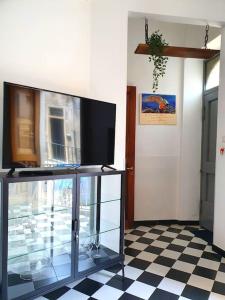 een kamer met een tv en een glazen kast bij Casa vacanze a Nicolosi - Etna - Black and White in Nicolosi