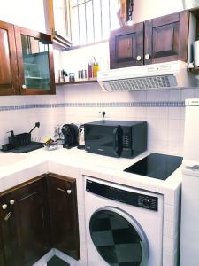 a kitchen with a microwave and a washing machine at Casa vacanze a Nicolosi - Etna - Black and White in Nicolosi