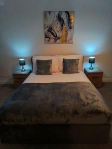 a bedroom with a large bed with two lamps at 14 Plants Yard in Worksop