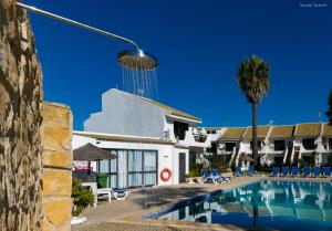 ラゴスにあるBelavista Torraltinha Flatのスイミングプールとタワー付きのホテル