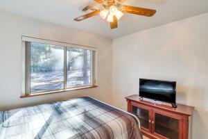 Schlafzimmer mit einem Bett, einem TV und einem Fenster in der Unterkunft Spacious Show Low Home Near Fool Hollow Lake! in Show Low