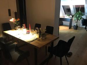 een eettafel met stoelen en een tafel met wijnglazen bij Großzügiges Loft mit Klimaanlage und Dachterrasse in Wenen