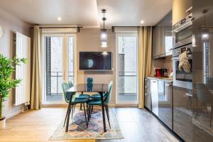 uma sala de jantar com uma mesa e cadeiras numa cozinha em Les Appartements Cardinet em Paris