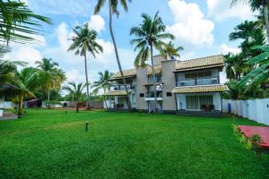 an exterior view of a house with palm trees at Backwater Brook in Kumarakom
