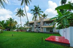 a view of a house with palm trees at Backwater Brook in Kumarakom