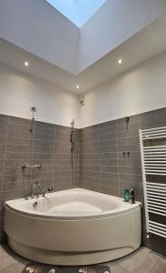 La salle de bains est pourvue d'une grande baignoire blanche. dans l'établissement AK Homes, a due passi da Orio, à Azzano San Paolo