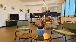 - un salon avec un vase sur une table et des chaises dans l'établissement AK Homes, a due passi da Orio, à Azzano San Paolo