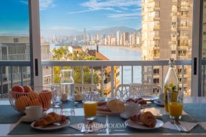 a table with plates of food and a view of a city at La Perla Benidorm Apartment seaview & pool Levante Beach in Benidorm