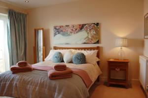 a bedroom with a bed with towels on it at Sunset Bay Beach House in Tywyn in Tywyn