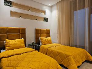 two beds in a room with yellow blankets at Genius 3 Bedroom Apartment with Beautiful Terrace Space, Casablanca in Casablanca
