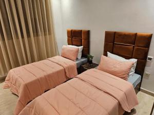 two beds with pink sheets in a room at Genius 3 Bedroom Apartment with Beautiful Terrace Space, Casablanca in Casablanca