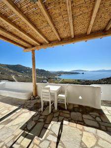 a table and chairs on a patio with a view at Cielo Azul Mykonos in Mikonos