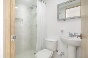 a white bathroom with a toilet and a sink at Bahari Cartagena Suites in Cartagena de Indias +40 photos