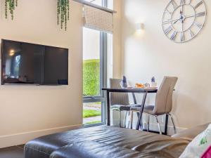 a living room with a table and a tv on the wall at 1 Bed in Blairgowrie 93427 in Rattray