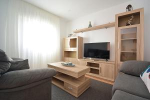 a living room with a couch and a television at Apartamento con vistas en Playa de As Sinas in Villanueva de Arosa