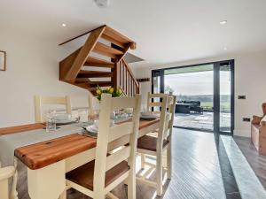 a dining room and kitchen with a wooden table and stairs at 3 Bed in Damerham 93357 in Damerham
