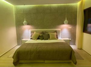 a bedroom with a large bed with two night lights at Villa Bahia in Casablanca