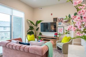 un soggiorno con divano rosa e TV di Brand New! 2 Bedroom Luxury Condo a Chatham