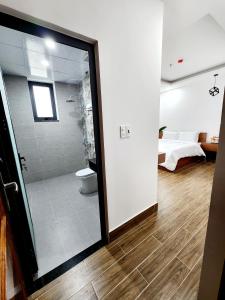 ein Bad mit einer Dusche und einem WC in einem Zimmer in der Unterkunft Happy Bun Hotel Da Lat in Da Lat