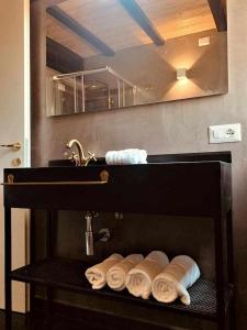 a bathroom with a sink and a rack of towels at My exclusive cavour loft da sogno a cagliari in Cagliari