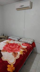 um quarto com uma cama com um cobertor de flores em Recanto do Descanso em Caxias do Sul