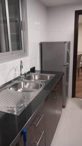 a kitchen with a sink and a refrigerator at Skyline Suites-Aventura de lujo in La Paz