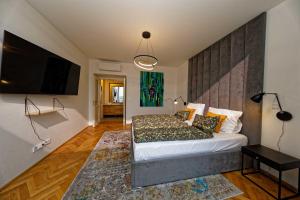 Schlafzimmer mit einem Bett und einem Flachbild-TV in der Unterkunft Exclusive maisonette above the park in Prag