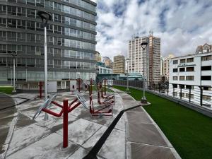 Skyline Suites-Aventura de lujo في لاباز: حديقة ذات مقاعد حمراء في مدينة ذات مباني طويلة